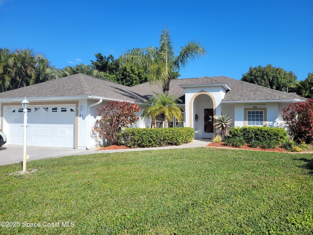 single story home featuring a garage and a front lawn