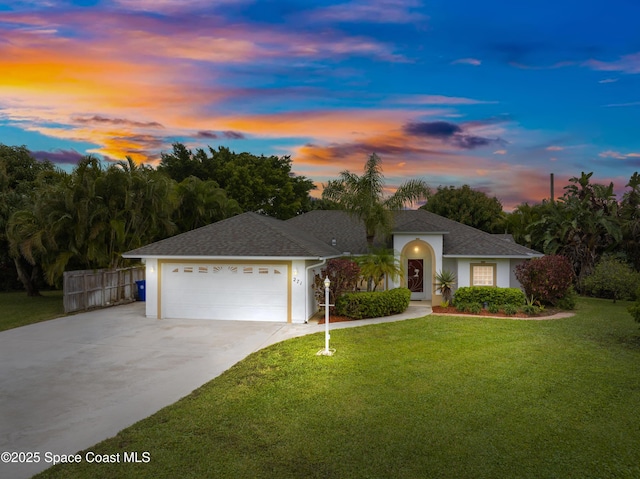 ranch-style house with a yard and a garage