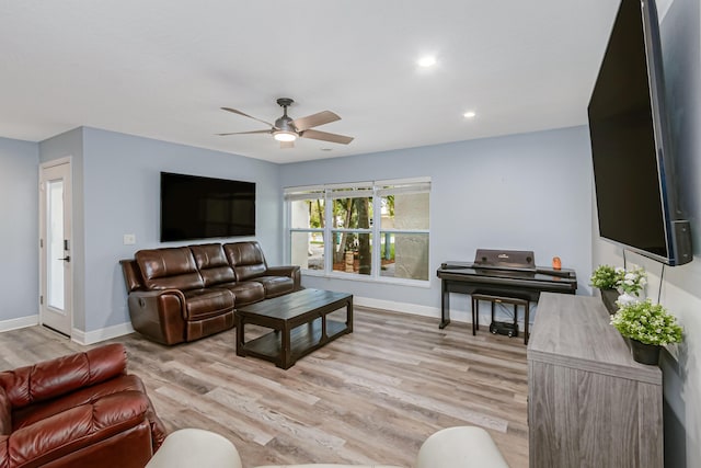 living room with light hardwood / wood-style floors and ceiling fan