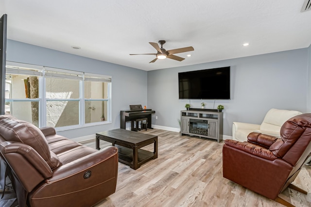 living room with light wood-type flooring and ceiling fan