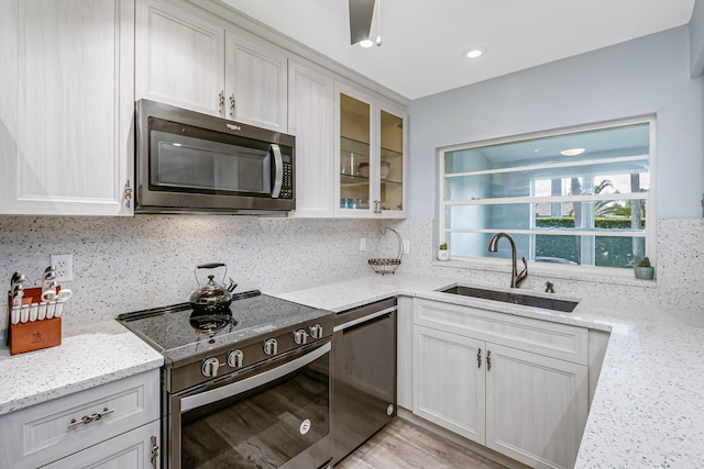 kitchen featuring appliances with stainless steel finishes, white cabinets, and backsplash