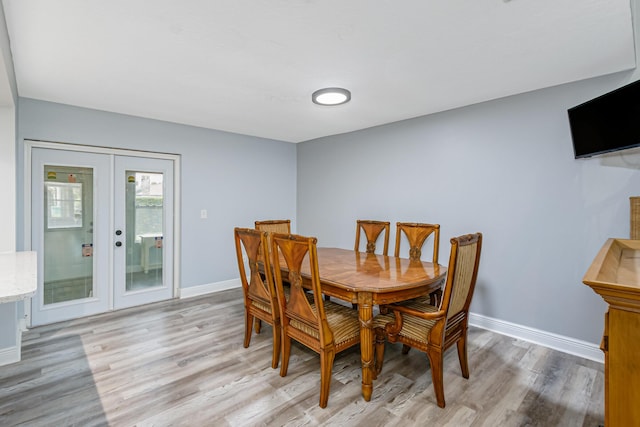 dining room featuring light wood-type flooring and french doors