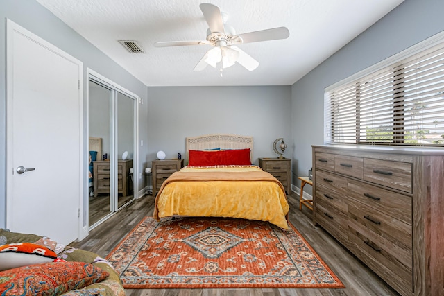 bedroom with a closet, ceiling fan, and dark hardwood / wood-style floors