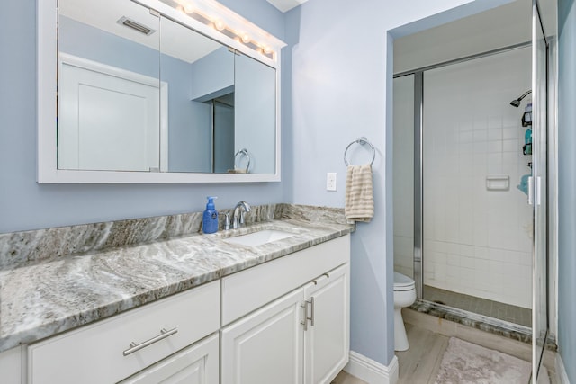 bathroom with toilet, walk in shower, and vanity