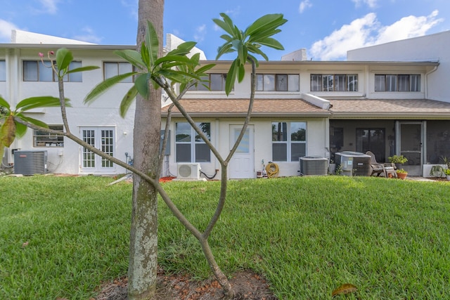 rear view of house with ac unit, central air condition unit, and a lawn