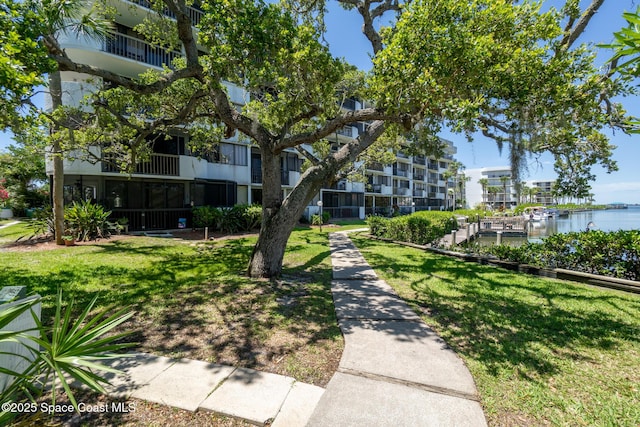 view of property's community with a yard and a water view