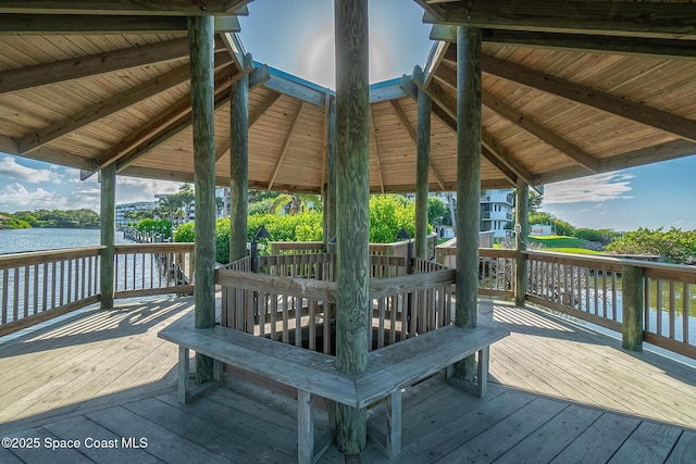 wooden terrace featuring a water view and a gazebo