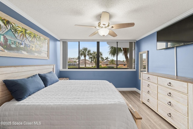 bedroom featuring ceiling fan, a textured ceiling, crown molding, and light wood-type flooring