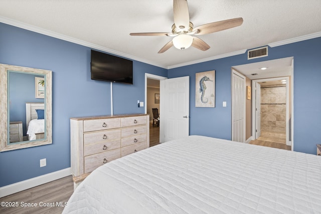 bedroom with ensuite bathroom, crown molding, a textured ceiling, light wood-type flooring, and ceiling fan