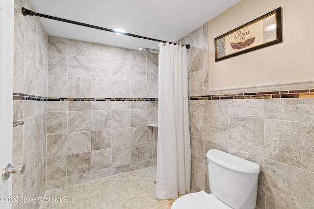 bathroom featuring toilet, tile walls, and a shower with curtain