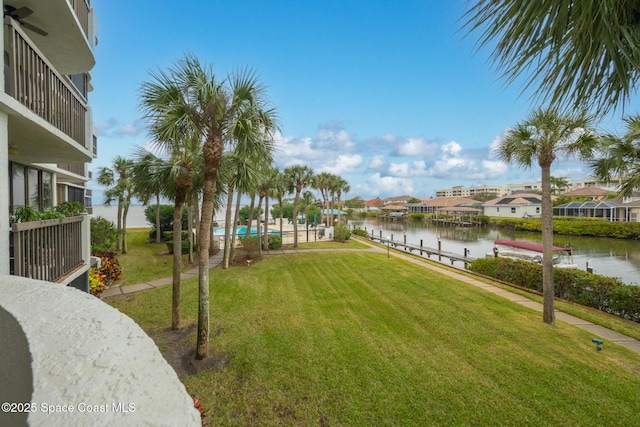 view of yard featuring a water view and a boat dock