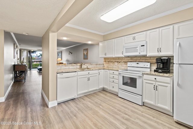 kitchen with sink, white appliances, white cabinets, and tasteful backsplash