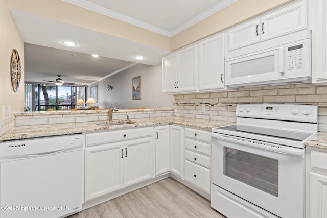 kitchen with white cabinetry, sink, white appliances, and light hardwood / wood-style floors