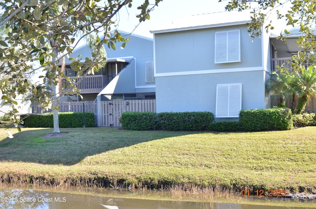 back of house featuring a water view and a yard