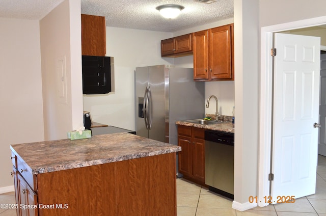 kitchen featuring sink, a textured ceiling, light tile patterned floors, and stainless steel appliances