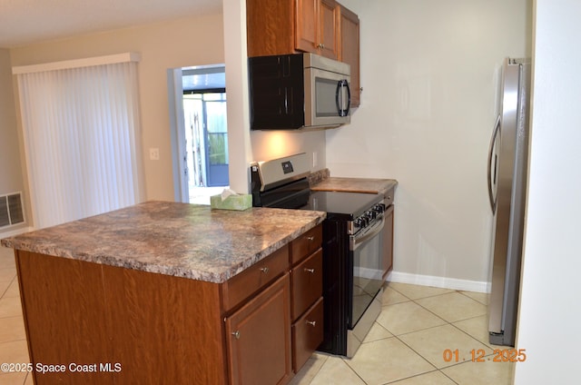 kitchen featuring light tile patterned flooring and stainless steel appliances