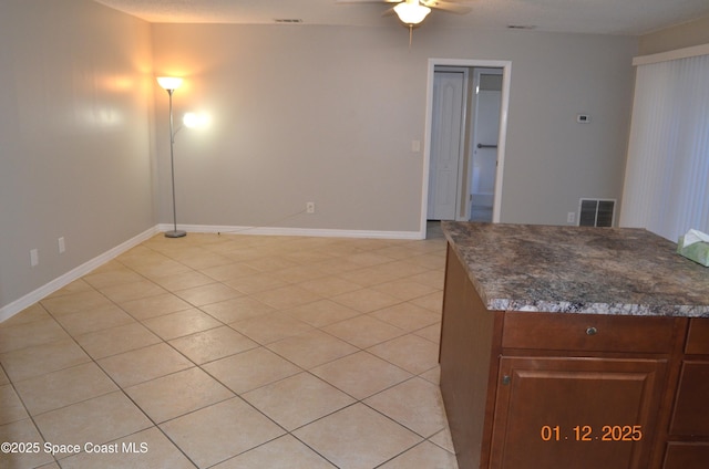 interior space with ceiling fan and light tile patterned flooring