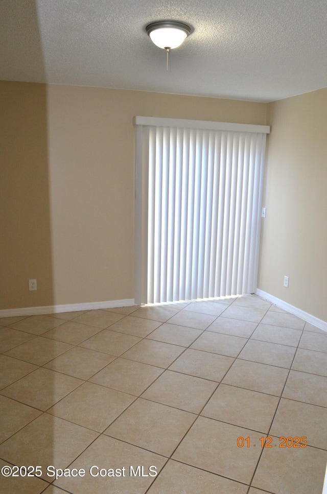 tiled spare room with a textured ceiling