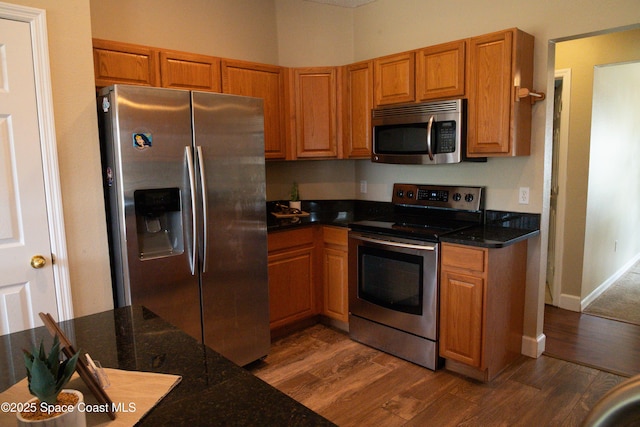 kitchen featuring stainless steel appliances and dark wood-type flooring