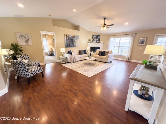 living room featuring lofted ceiling, dark wood-type flooring, and ceiling fan