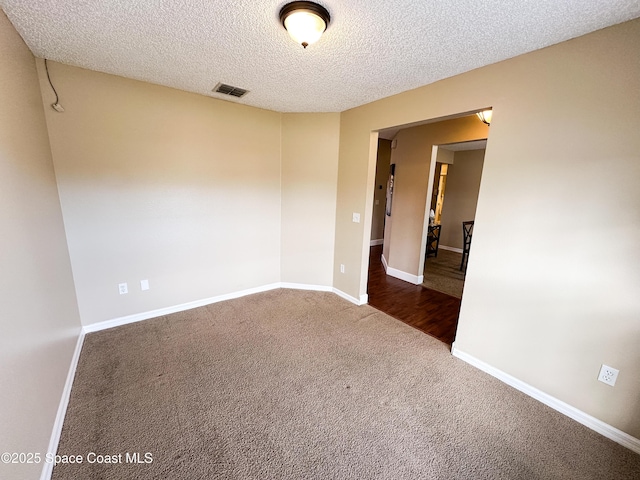 carpeted spare room with a textured ceiling