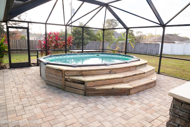 view of pool featuring a lanai, a patio area, and a hot tub