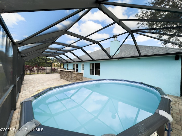 view of pool with a patio area and glass enclosure