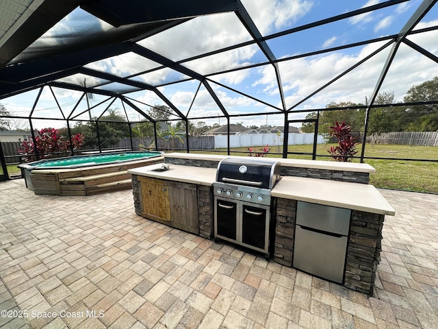 view of patio featuring an outdoor kitchen, a grill, a lanai, and a jacuzzi