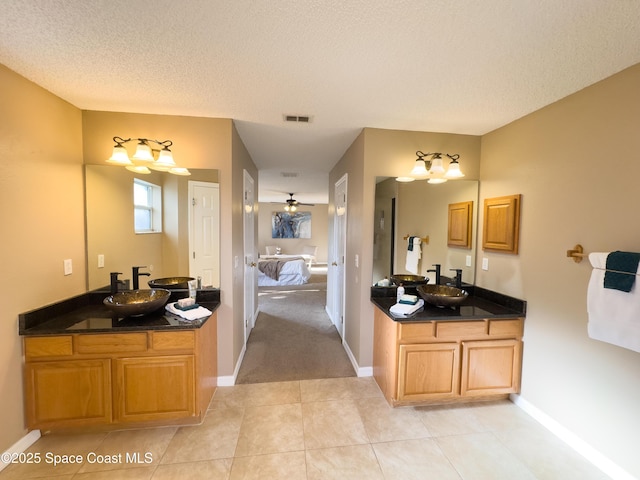 bathroom featuring vanity, tile patterned floors, and a textured ceiling