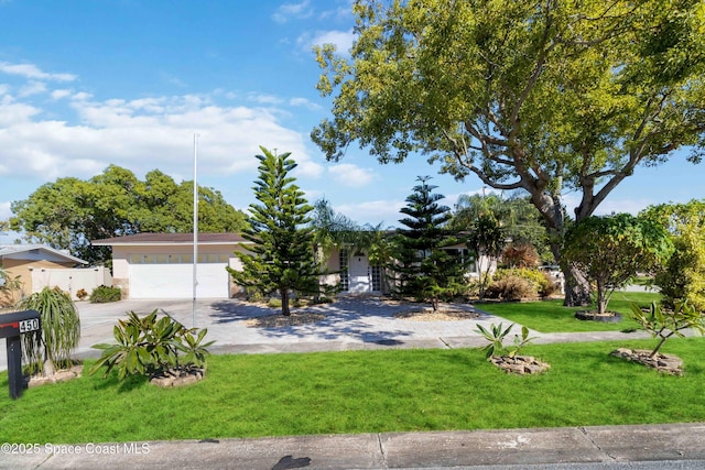 view of front of property featuring a front yard and a garage