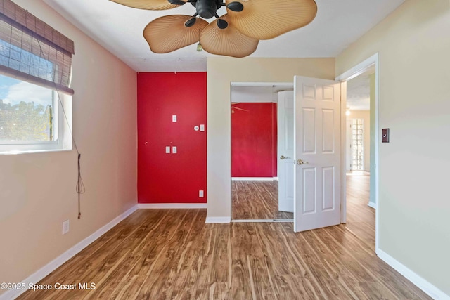 unfurnished bedroom with ceiling fan, wood-type flooring, and a closet