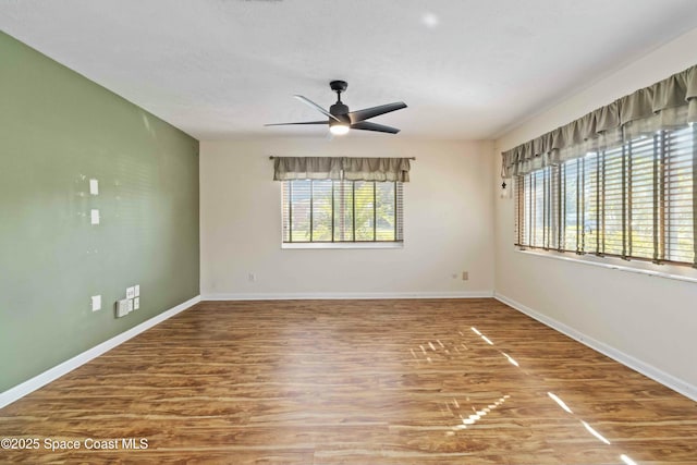 unfurnished room featuring ceiling fan, hardwood / wood-style floors, and a wealth of natural light