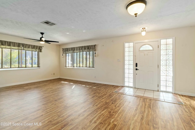 entrance foyer with hardwood / wood-style floors, a textured ceiling, and a healthy amount of sunlight