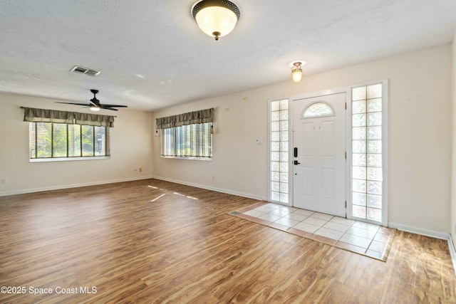 foyer entrance with hardwood / wood-style flooring and a textured ceiling