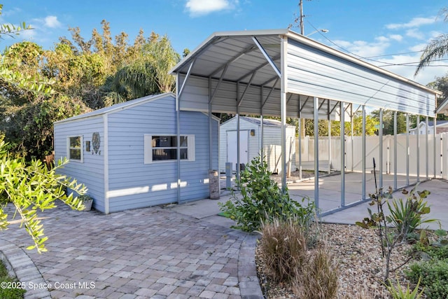 view of patio / terrace with a carport and a storage shed