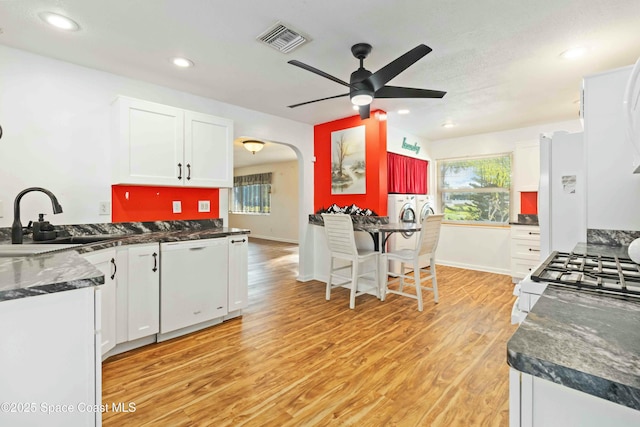 kitchen with white appliances, white cabinets, and sink