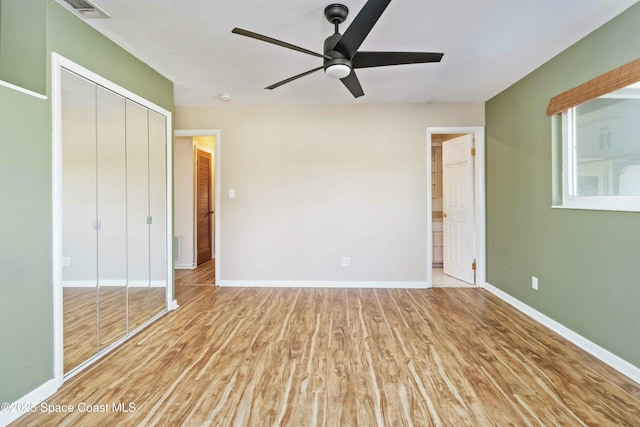 unfurnished bedroom with light hardwood / wood-style flooring, a closet, and ceiling fan