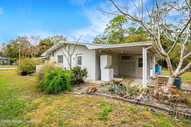 view of home's exterior featuring a lawn and a carport