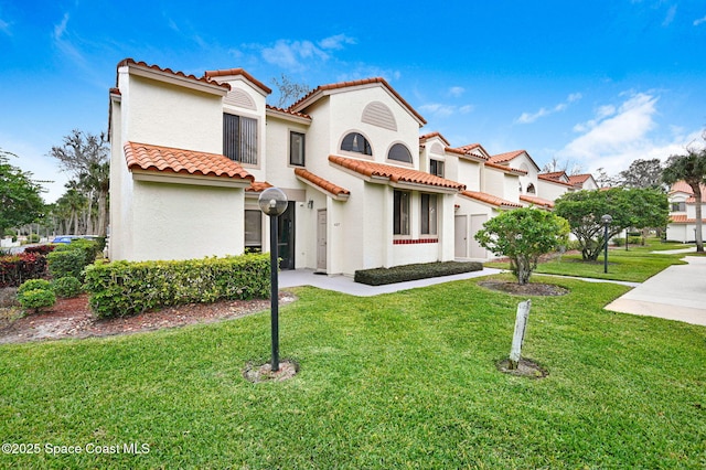 mediterranean / spanish home with a front yard