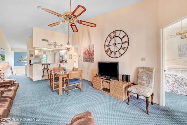 living room with lofted ceiling, ceiling fan, and carpet