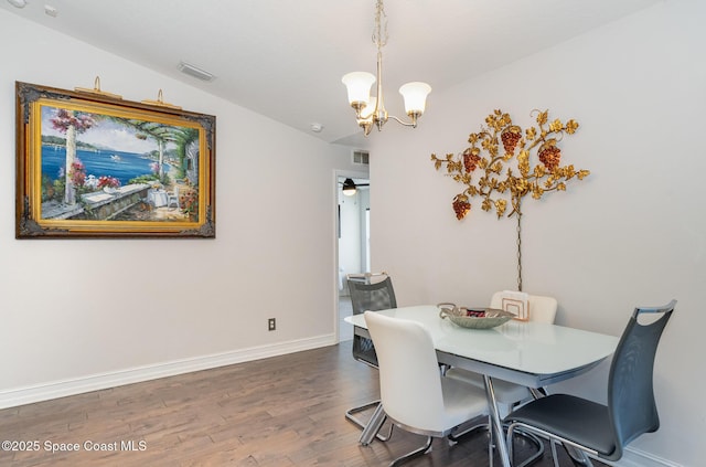 dining area featuring vaulted ceiling, ceiling fan with notable chandelier, and dark hardwood / wood-style floors