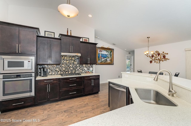 kitchen with decorative light fixtures, sink, backsplash, and stainless steel appliances