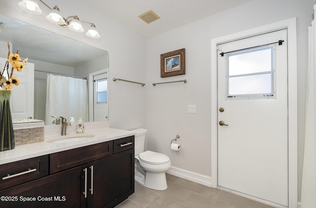 bathroom featuring vanity, toilet, and tile patterned flooring