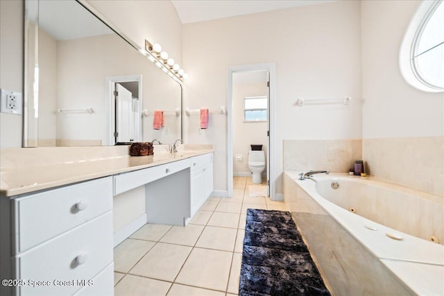 bathroom featuring vanity, tiled tub, tile patterned floors, and toilet