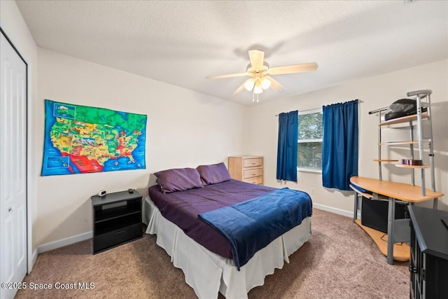 bedroom with carpet floors, a textured ceiling, ceiling fan, and a closet