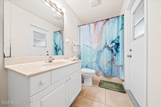 bathroom featuring tile patterned flooring, vanity, toilet, and a textured ceiling