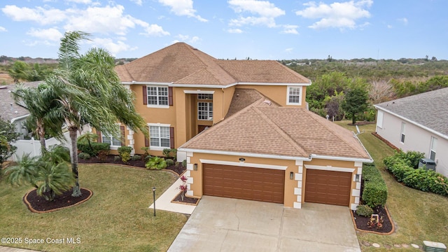 view of front of home with a garage, cooling unit, and a front lawn