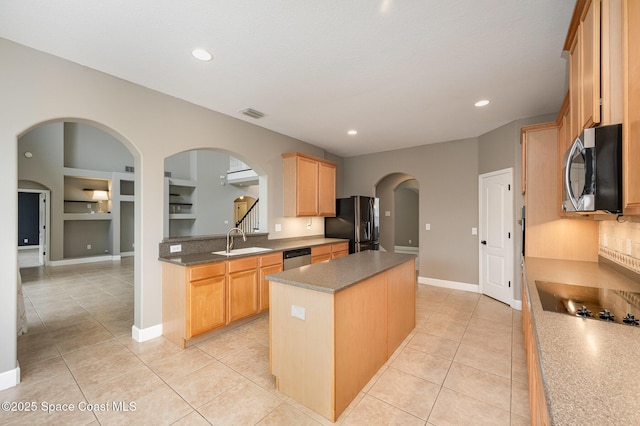 kitchen with a kitchen island, stainless steel appliances, sink, built in features, and light tile patterned floors