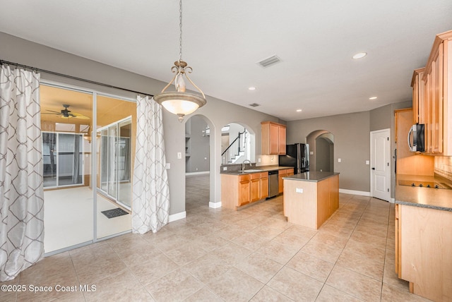 kitchen featuring pendant lighting, sink, light tile patterned floors, a center island, and stainless steel appliances