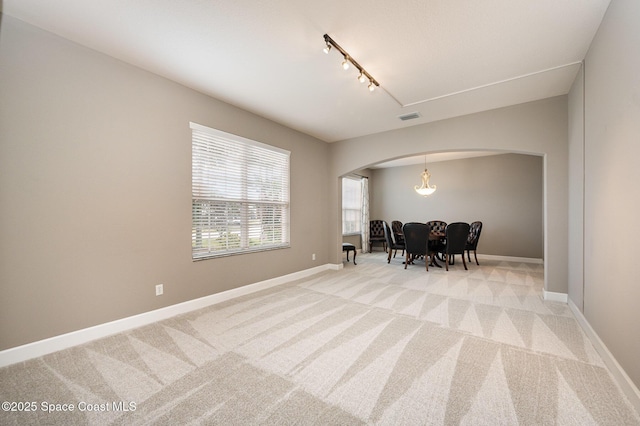 interior space with rail lighting and light carpet